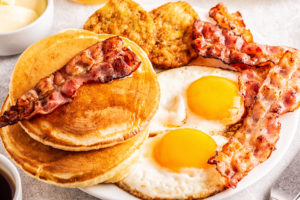 Healthy Full American Breakfast with Eggs Bacon Pancakes and Latkes, selective focus.